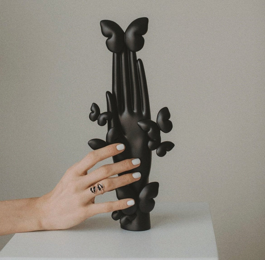 Black sculpture of ‘Metamorphosis’ symbolizing rebirth and new beginnings.